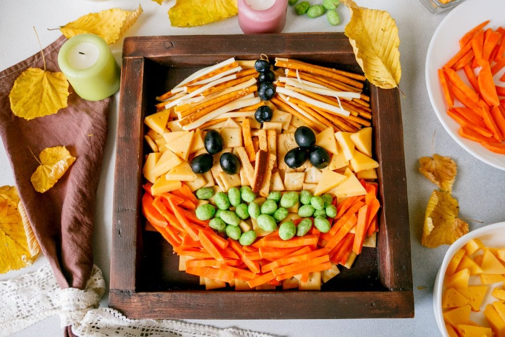 Scarecrow pumpkin snack board with cheese platter.