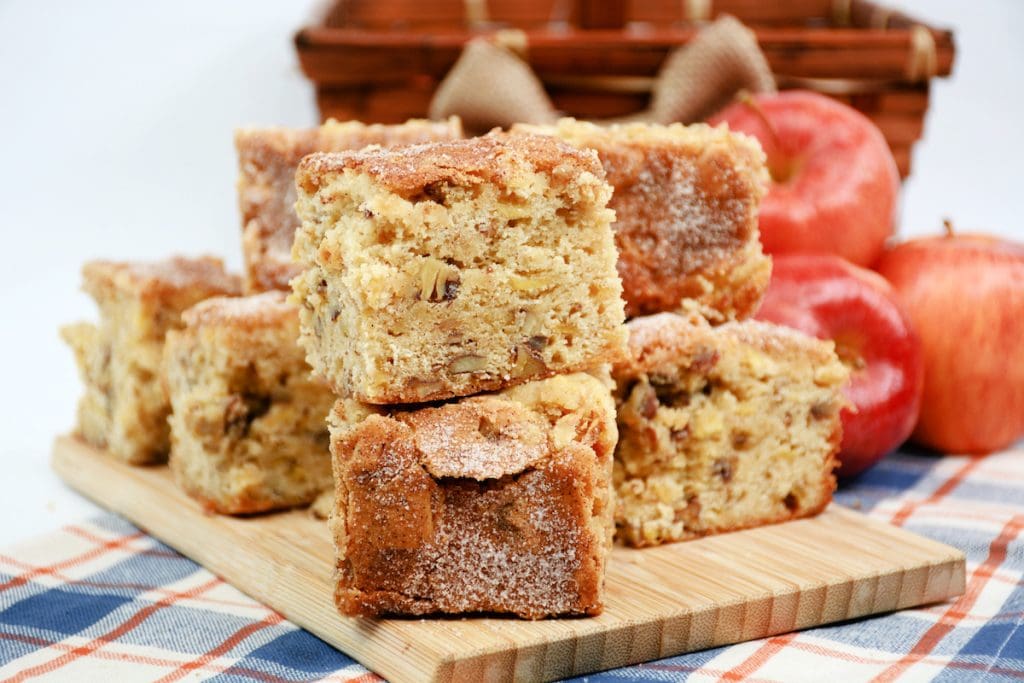 A stack of apple cake on a wooden cutting board.