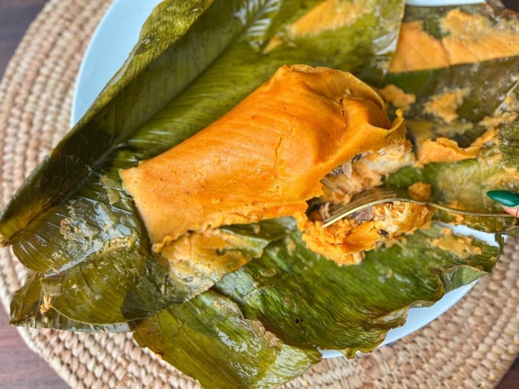 A banana leaf with a piece of moi moi on it.