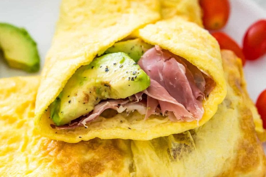 A ham and avocado omelet on a plate.