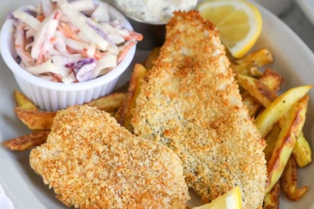 Fried fish with fries and coleslaw on a plate.