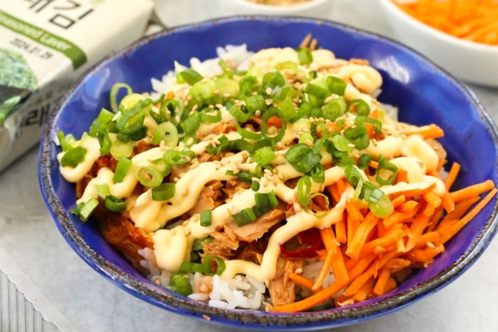 A blue bowl with chicken, carrots and rice.