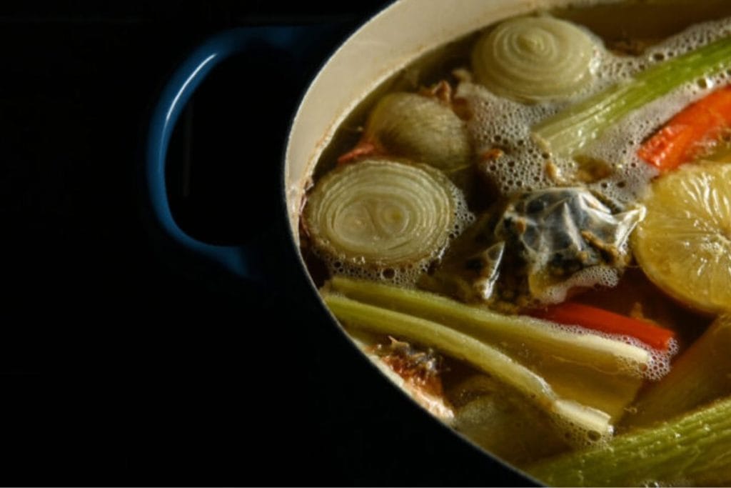 A pot of soup with vegetables in it.
