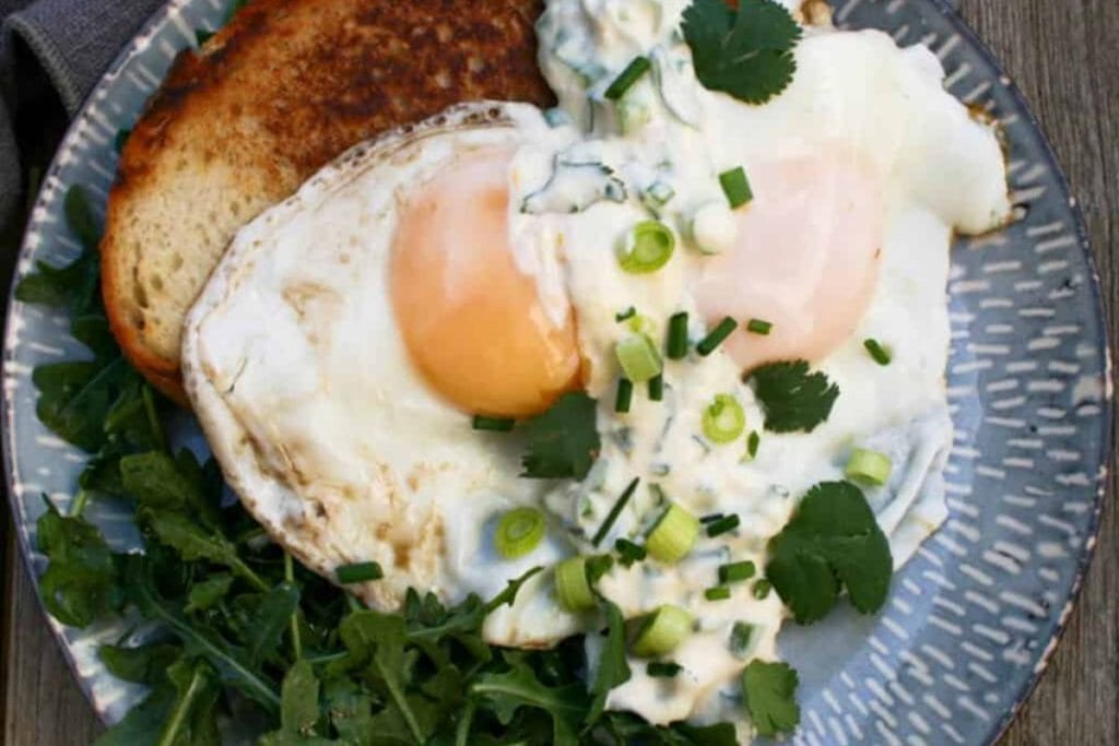 A plate with a fried egg and greens on it.