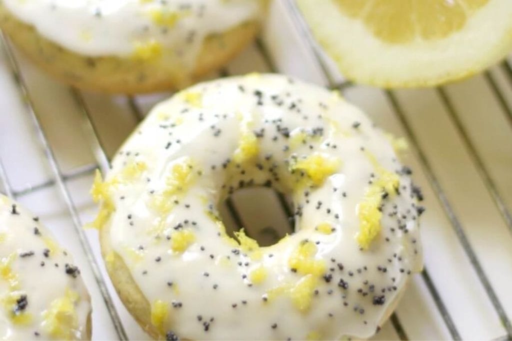 Lemon poppy seed donuts on a cooling rack.