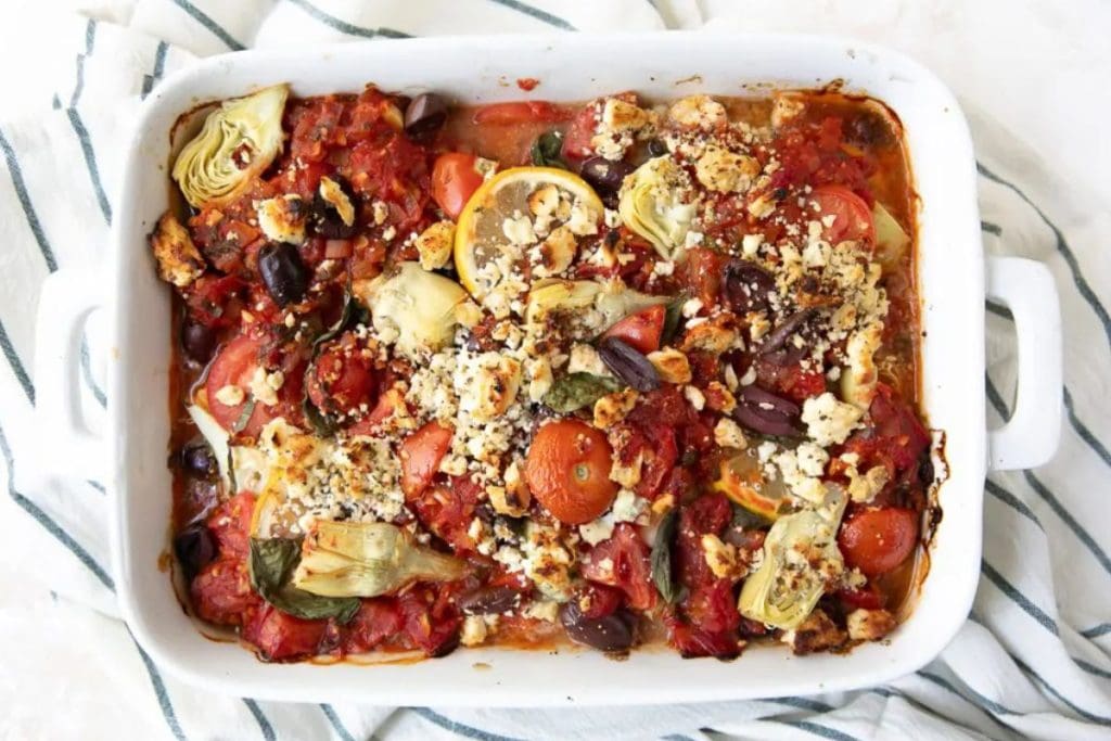 A casserole dish filled with vegetables and tomatoes.