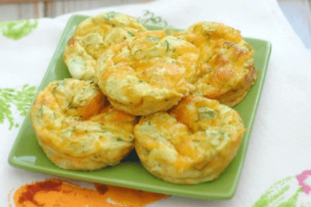 Cheesy zucchini muffins on a green plate.