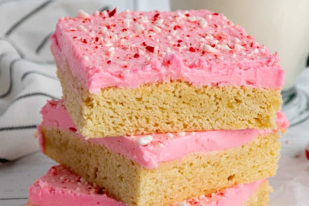 Pink peppermint cookie bars stacked on top of each other.