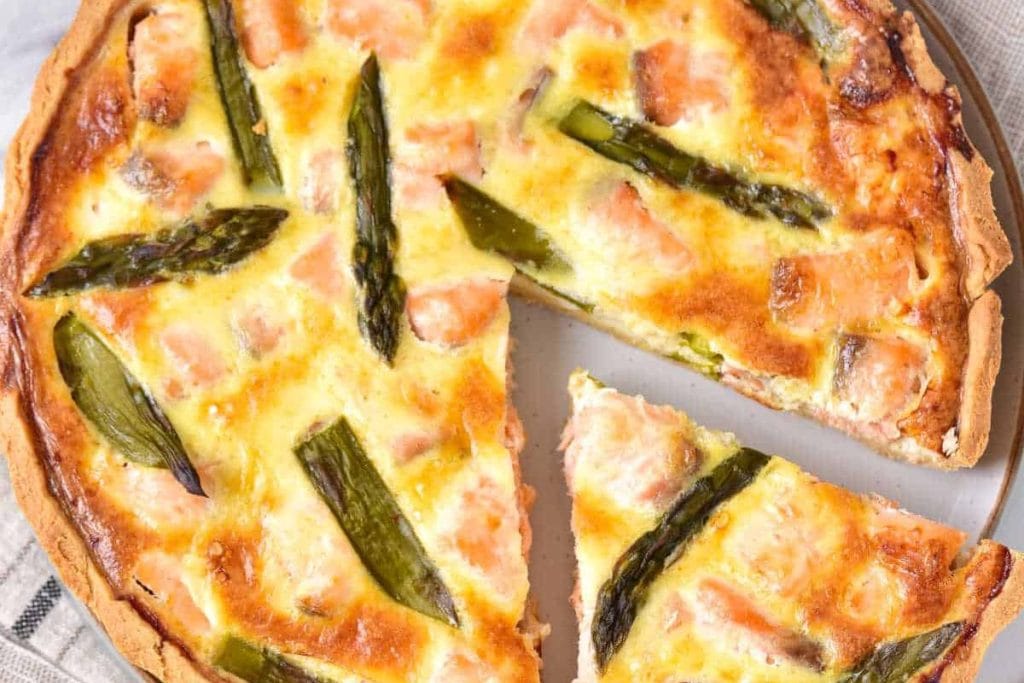 Salmon and asparagus quiche with a slice taken out.