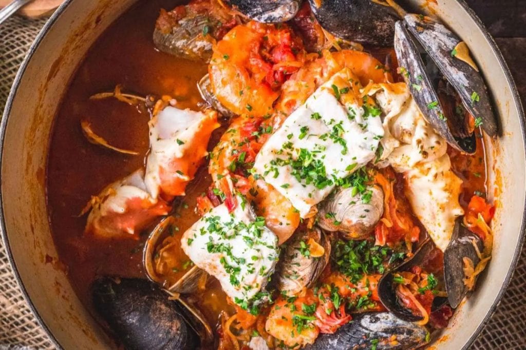 A pot of seafood stew with clams and mussels.