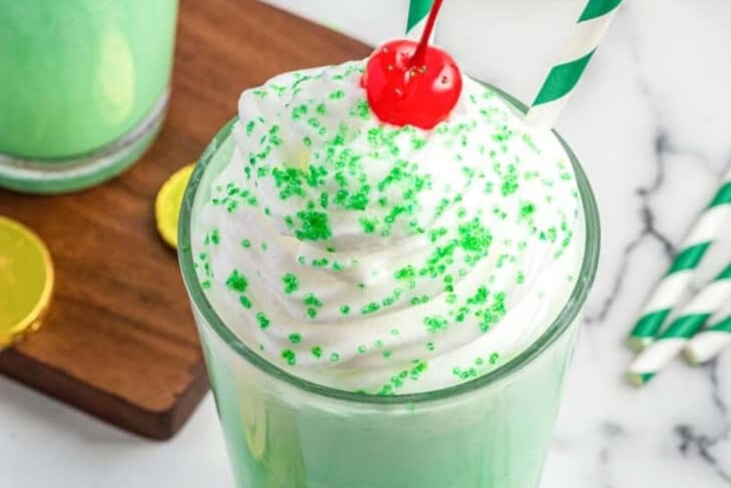 St patrick's day milkshake with whipped cream and green sprinkles.