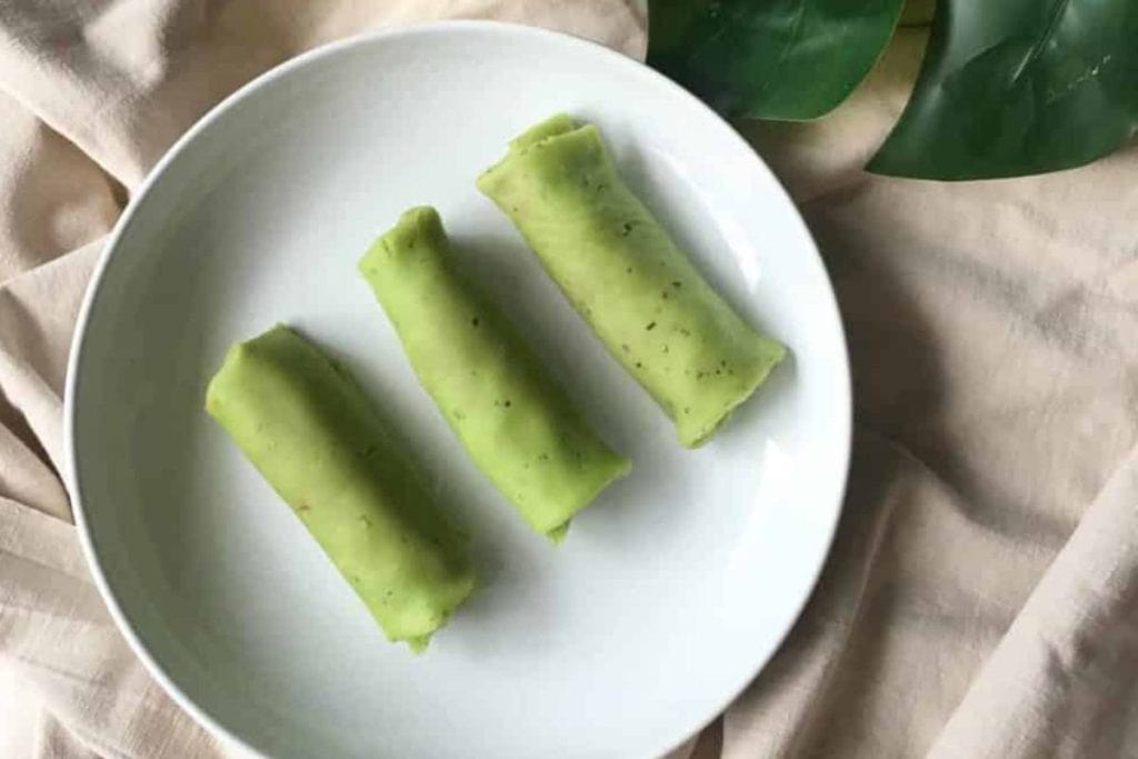 Three green rolls on a white plate.
