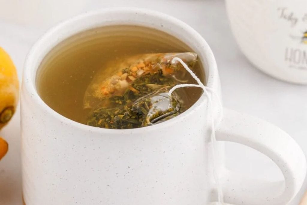 A cup of tea with lemons and green tea.