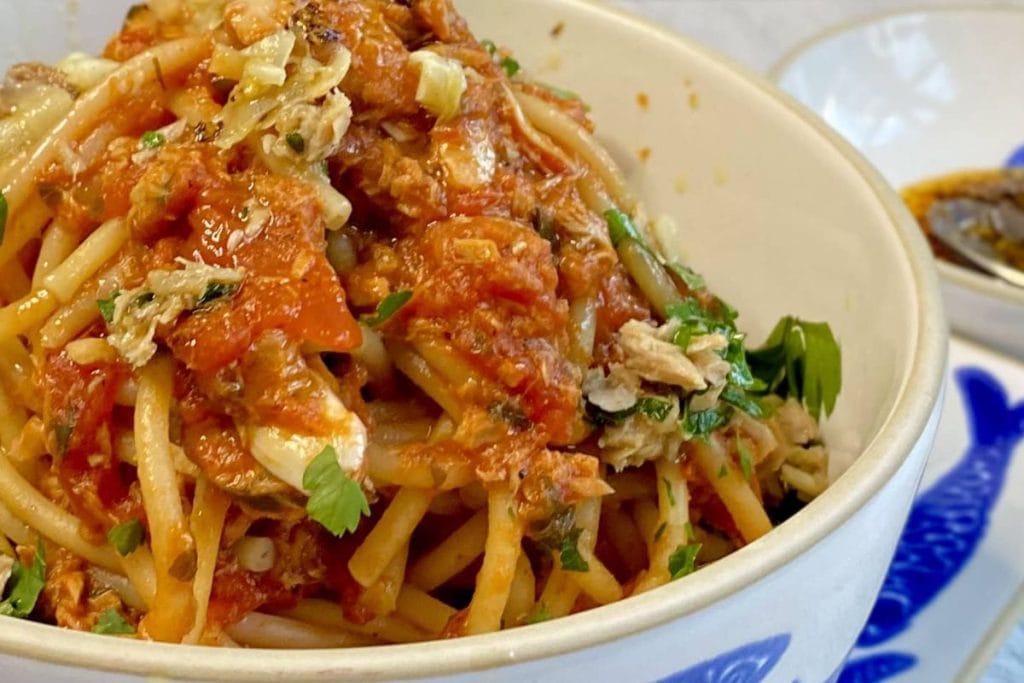 A bowl of spaghetti with sauce and sauce.