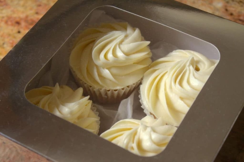 Cupcakes in a silver box with white frosting.