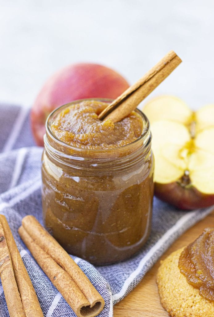 An irresistible jar of homemade apple butter featuring flavorful cinnamon sticks and fresh apples.