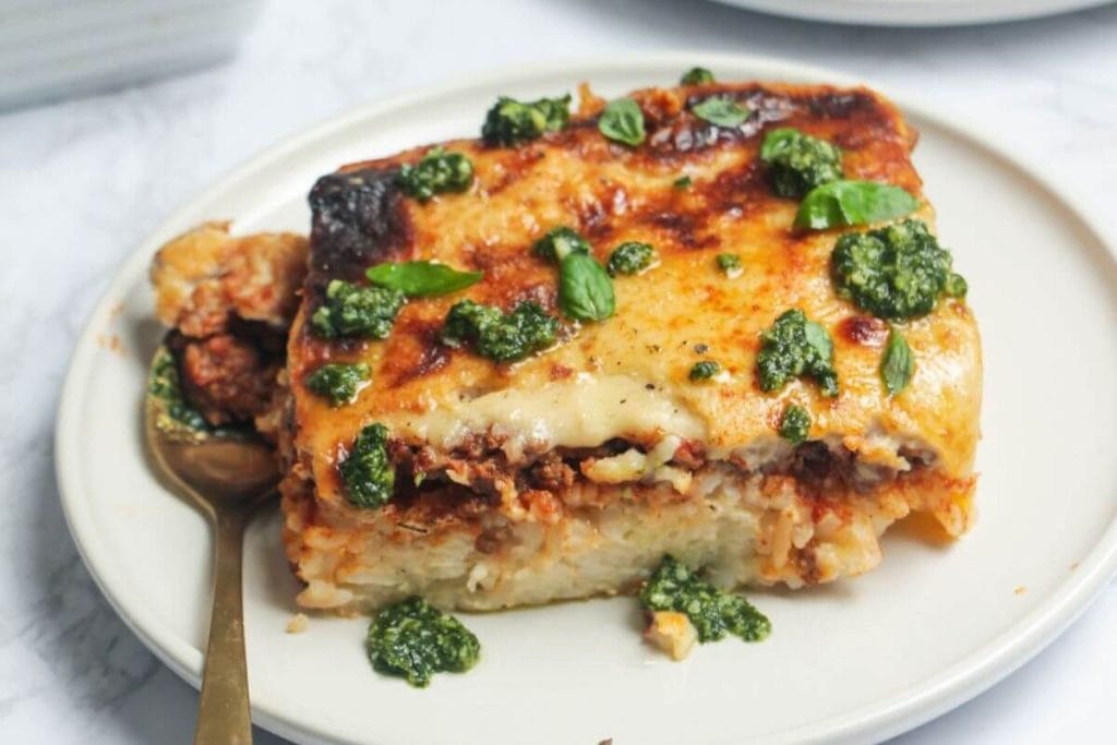 Last-Minute Potluck Ideas: A slice of lasagna with pesto sauce on a plate.