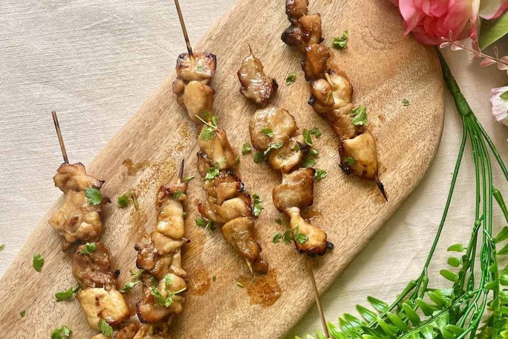 Chicken skewers on a wooden cutting board, perfect for Last-Minute Potluck Ideas.