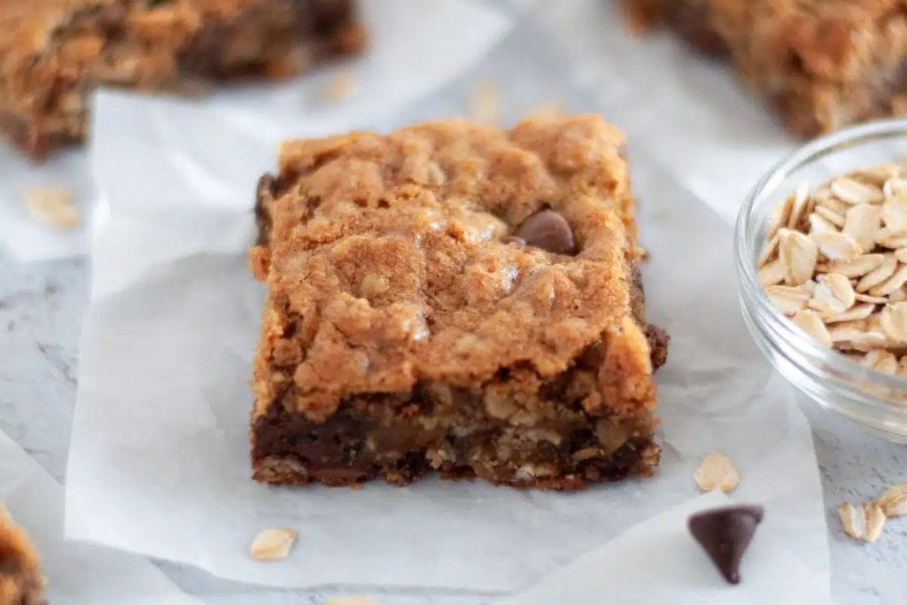 Last-Minute Potluck Ideas: A slice of chocolate oat bars with a bowl of oats.