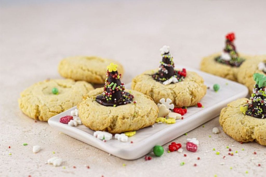 Christmas cookies with sprinkles on a white plate.