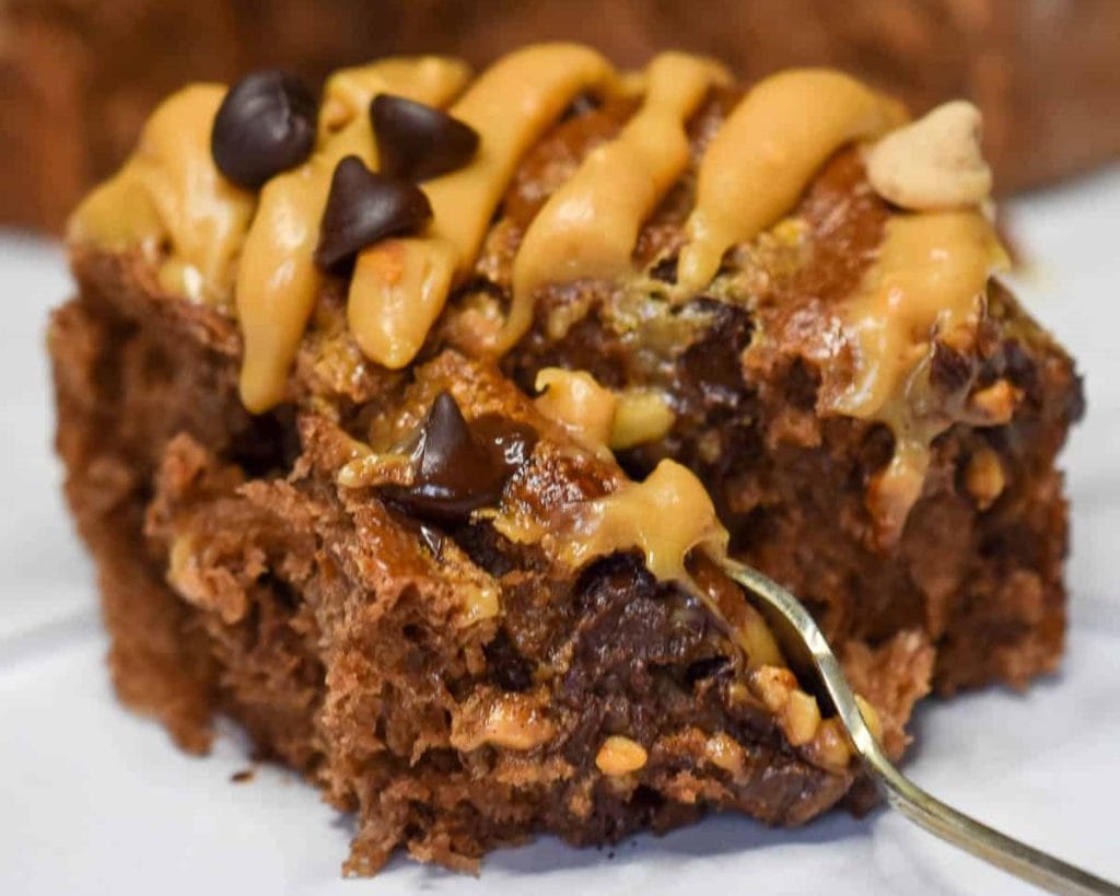 A bite of chocolate peanut butter cake on a plate.