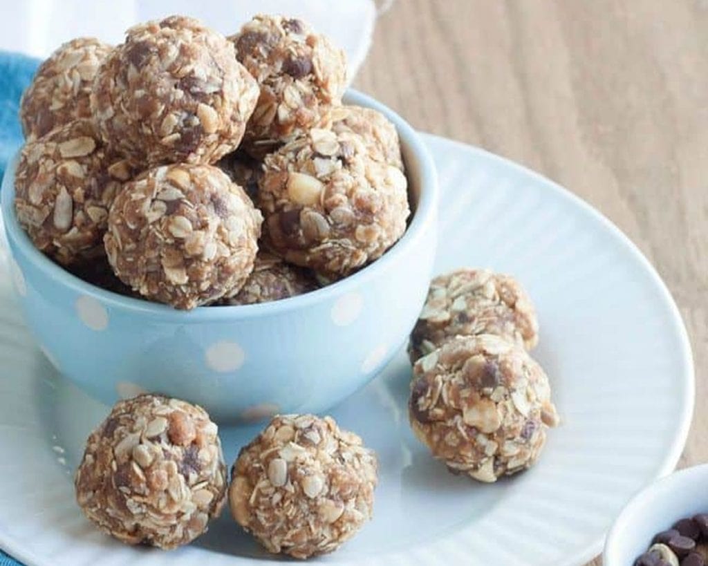 A bowl full of granola energy bites on a blue plate.