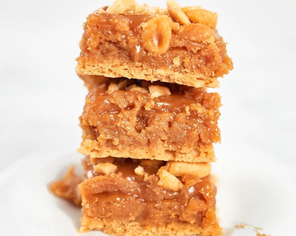 A stack of peanut butter bars on a white plate.