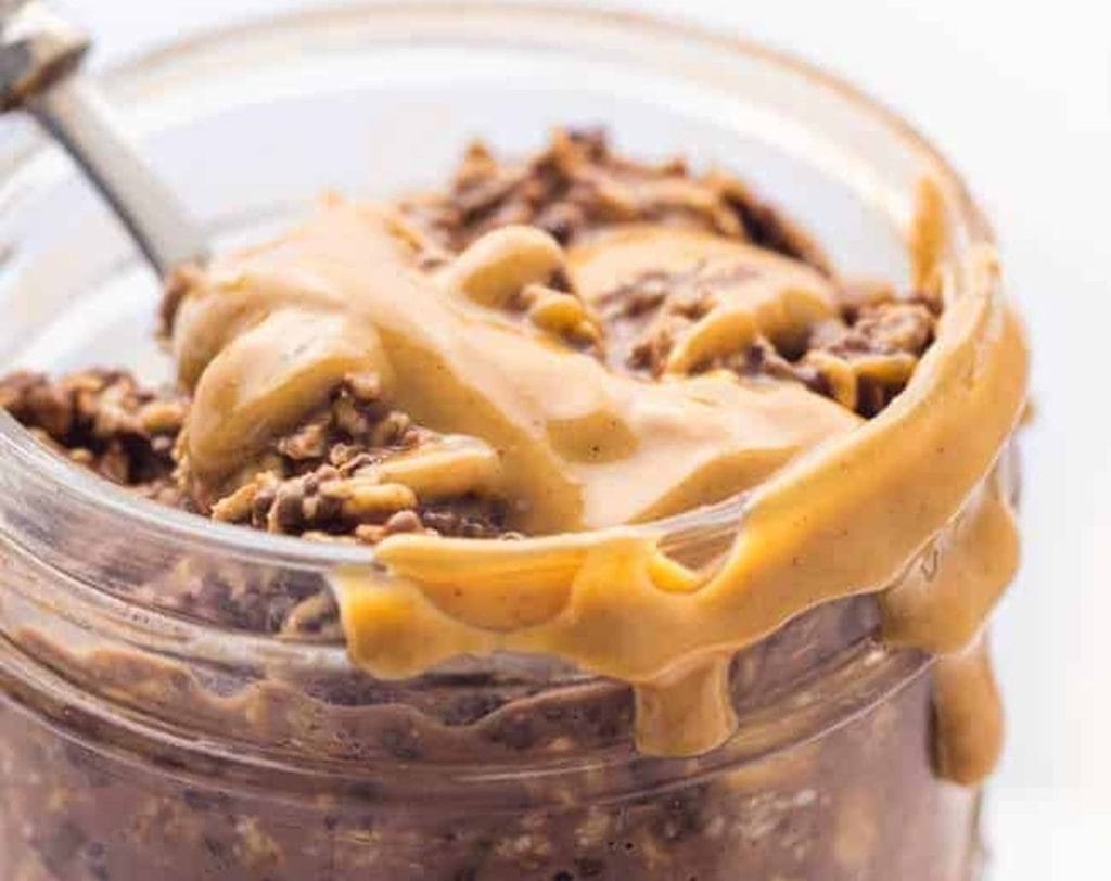 Peanut butter oatmeal in a jar with a spoon.