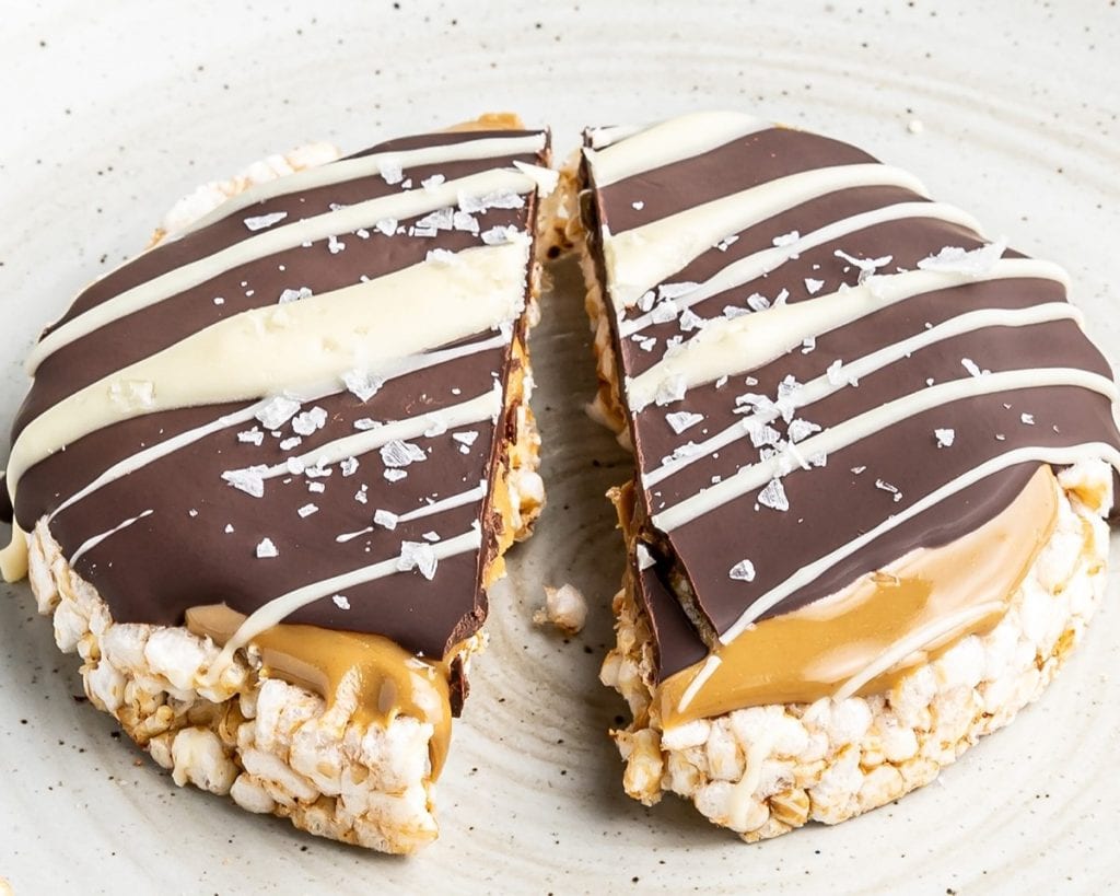 A plate with a peanut butter and chocolate covered rice krispie treat.