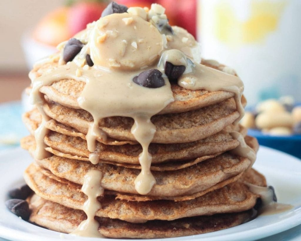 A stack of pancakes with peanut butter and chocolate sauce.