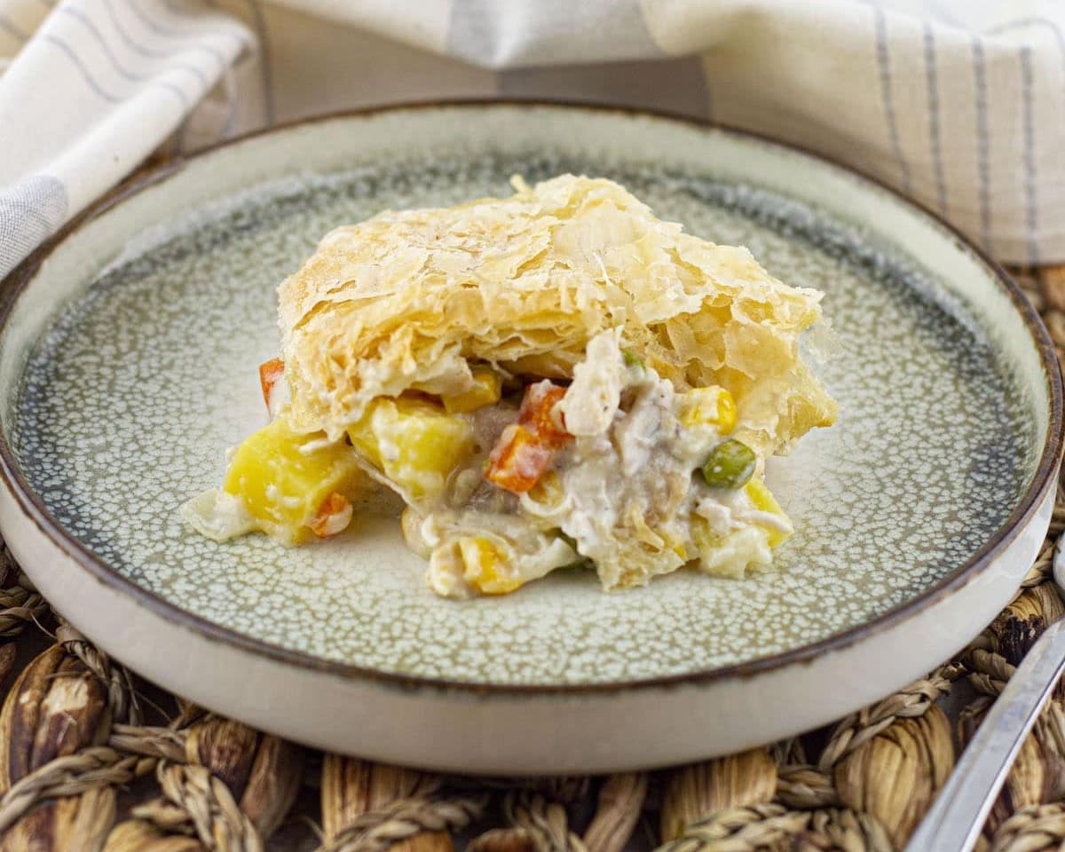 A piece of chicken pot pie on a ceramic plate, perfect for last-minute dinner ideas.