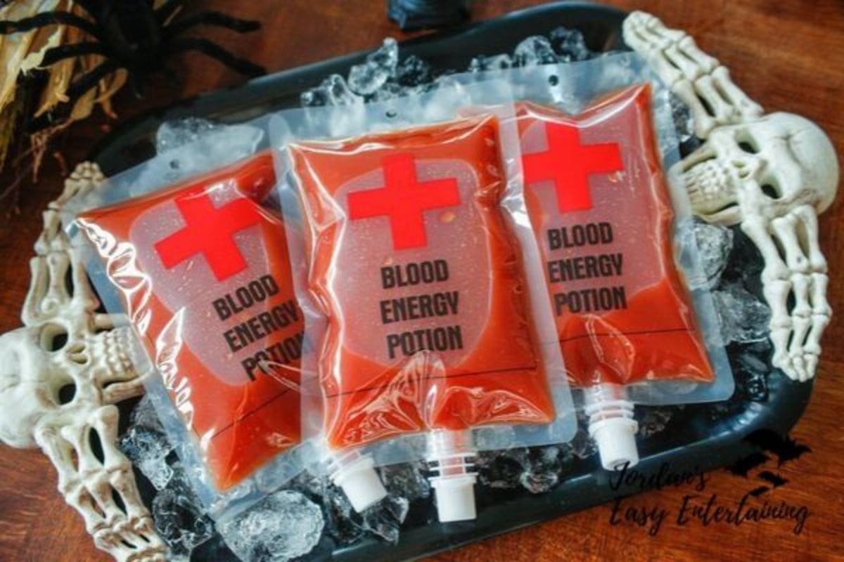 Three pouches labeled "Blood Energy Potion" with red cross symbols are placed on a tray with ice, surrounded by skull decorations.