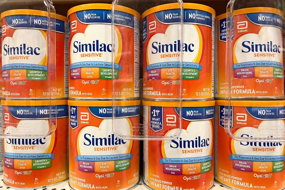 Shelves of Similac Sensitive infant formula containers displayed in a store.