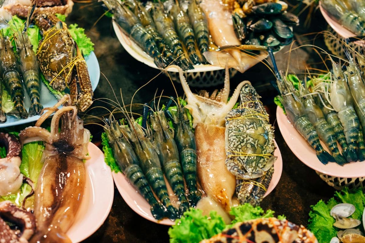Assorted seafood, including prawns, crabs, and squid, arranged on plates with lettuce.
