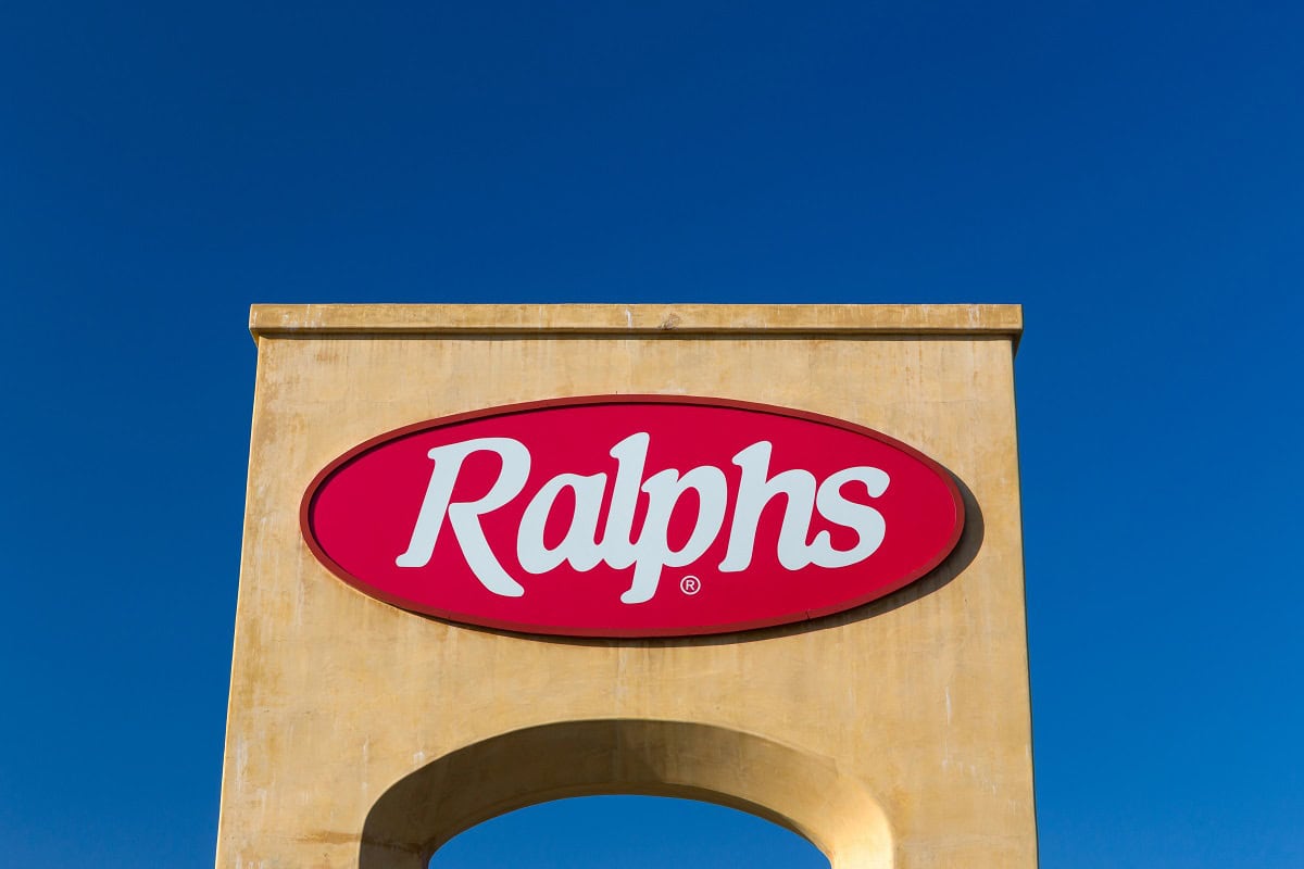 A Ralphs supermarket sign on a yellow structure against a clear blue sky.