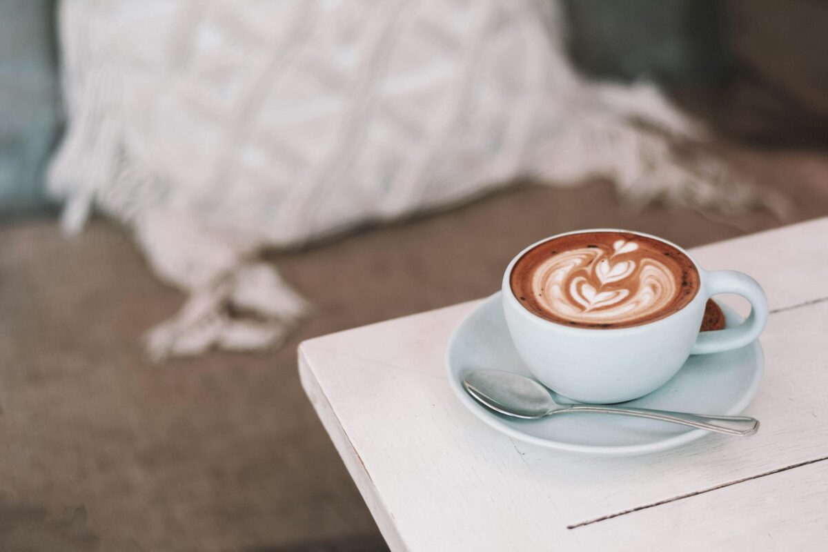 Latte with beautiful art in cozy café setting, perfect for morning relaxation.