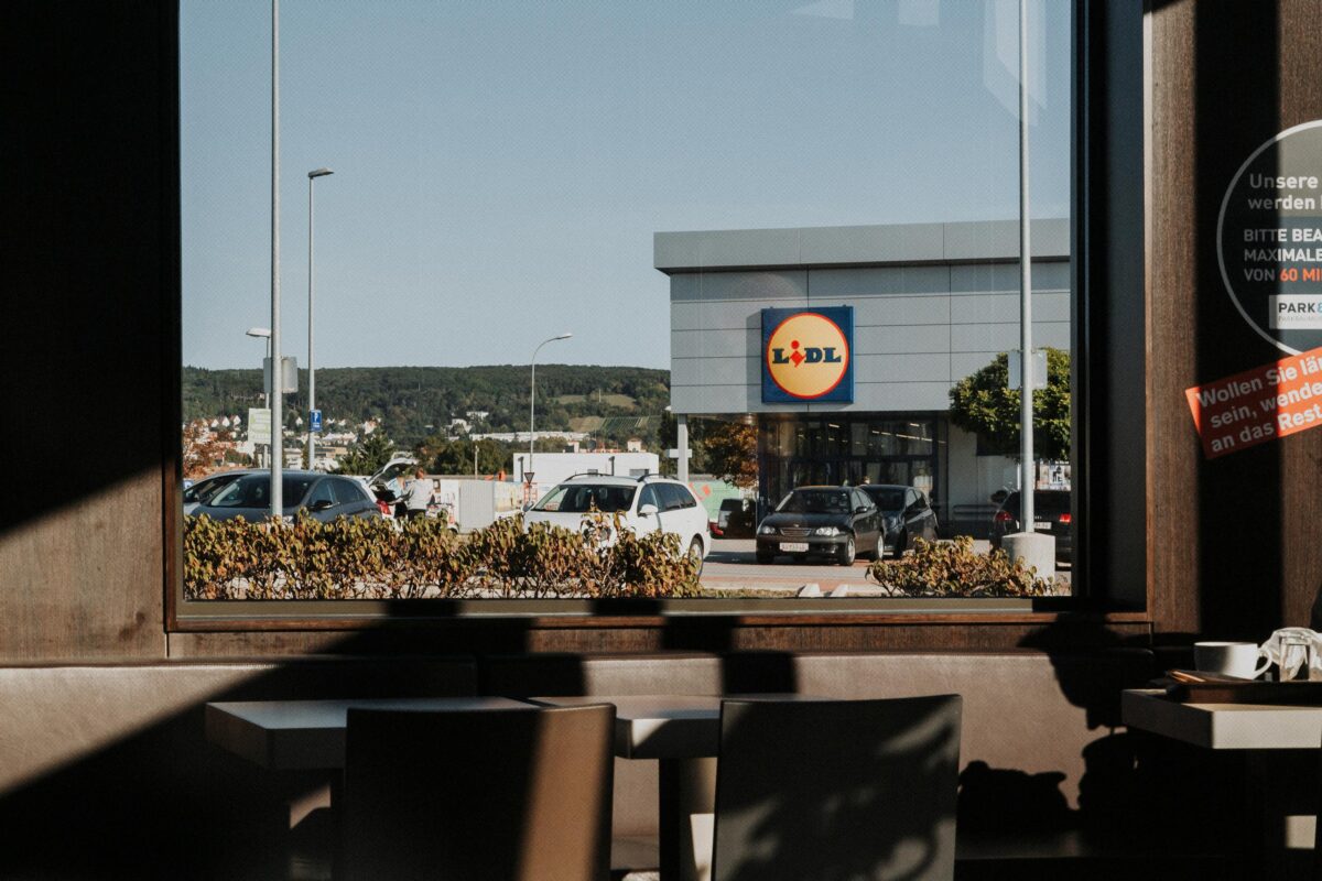 View from a café window showing a Lidl store and parked cars in Austria.