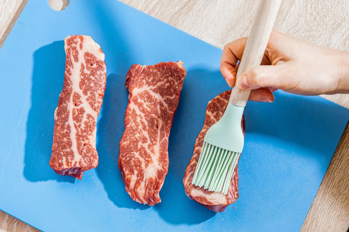 Brush oil on meat