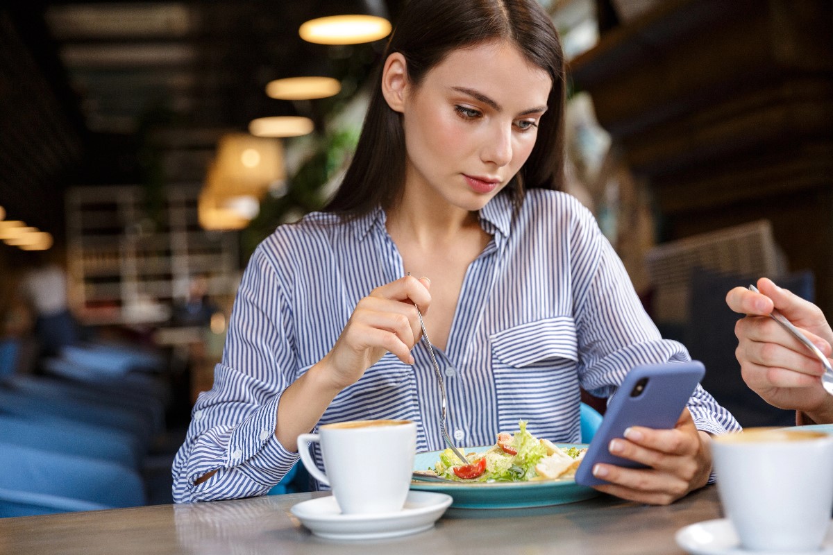 Woman using phone in restaurant